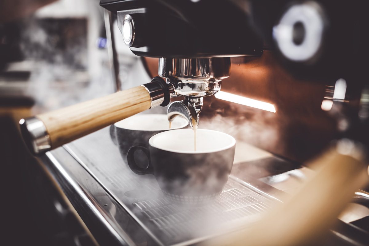 Coffee being poured from a coffee machine into a mug in El Paso.