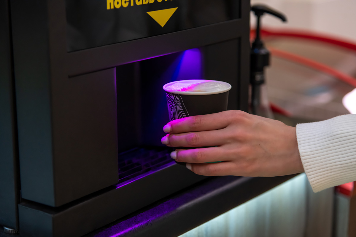 A person getting a cup of coffee from a machine in an El Paso micro market.